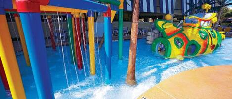 A water play area with colorful structures and a large inflatable vehicle.
