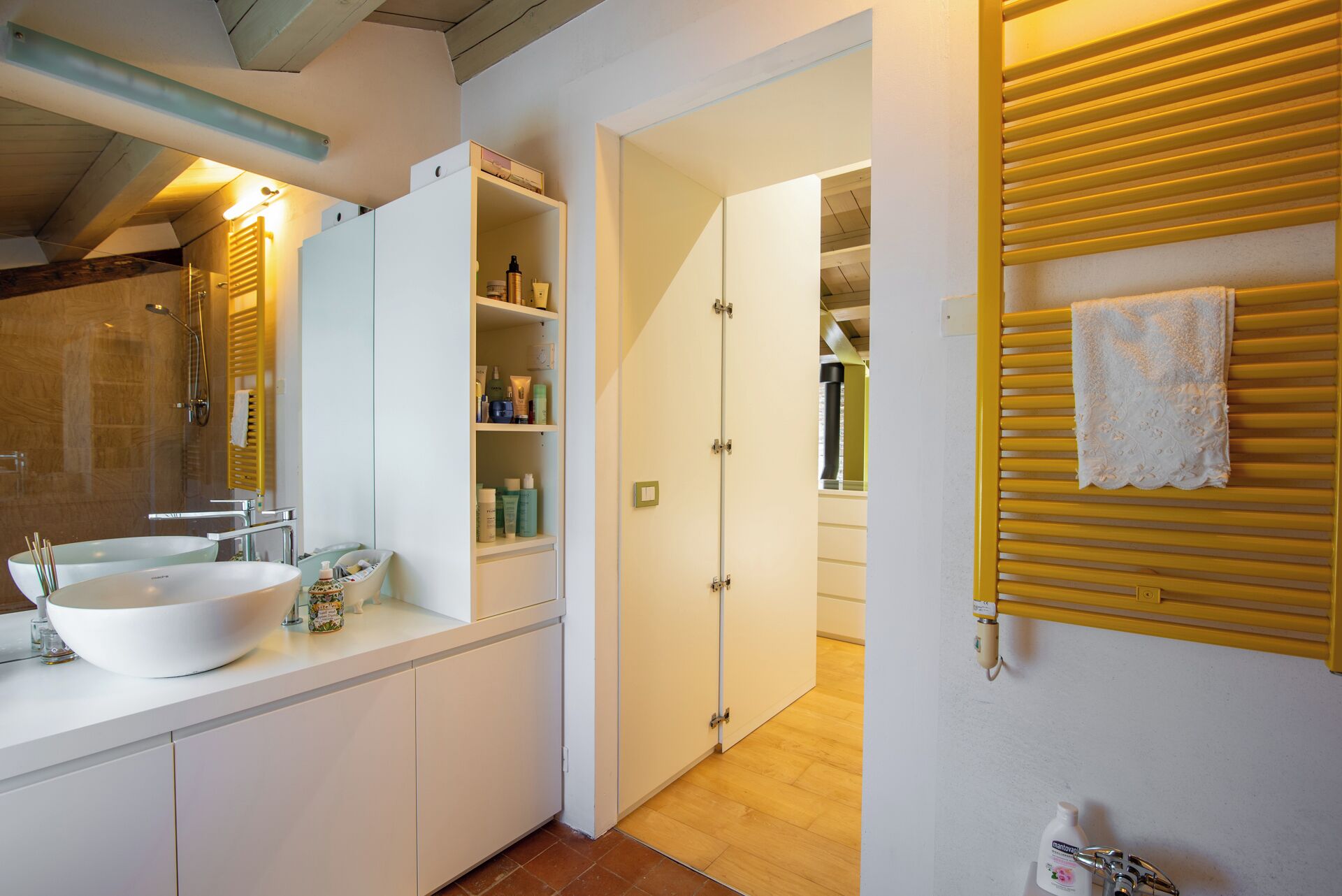 Ein modernes Badezimmer mit zwei Waschbecken, einer Dusche und einem Waschtisch mit Stauraum.