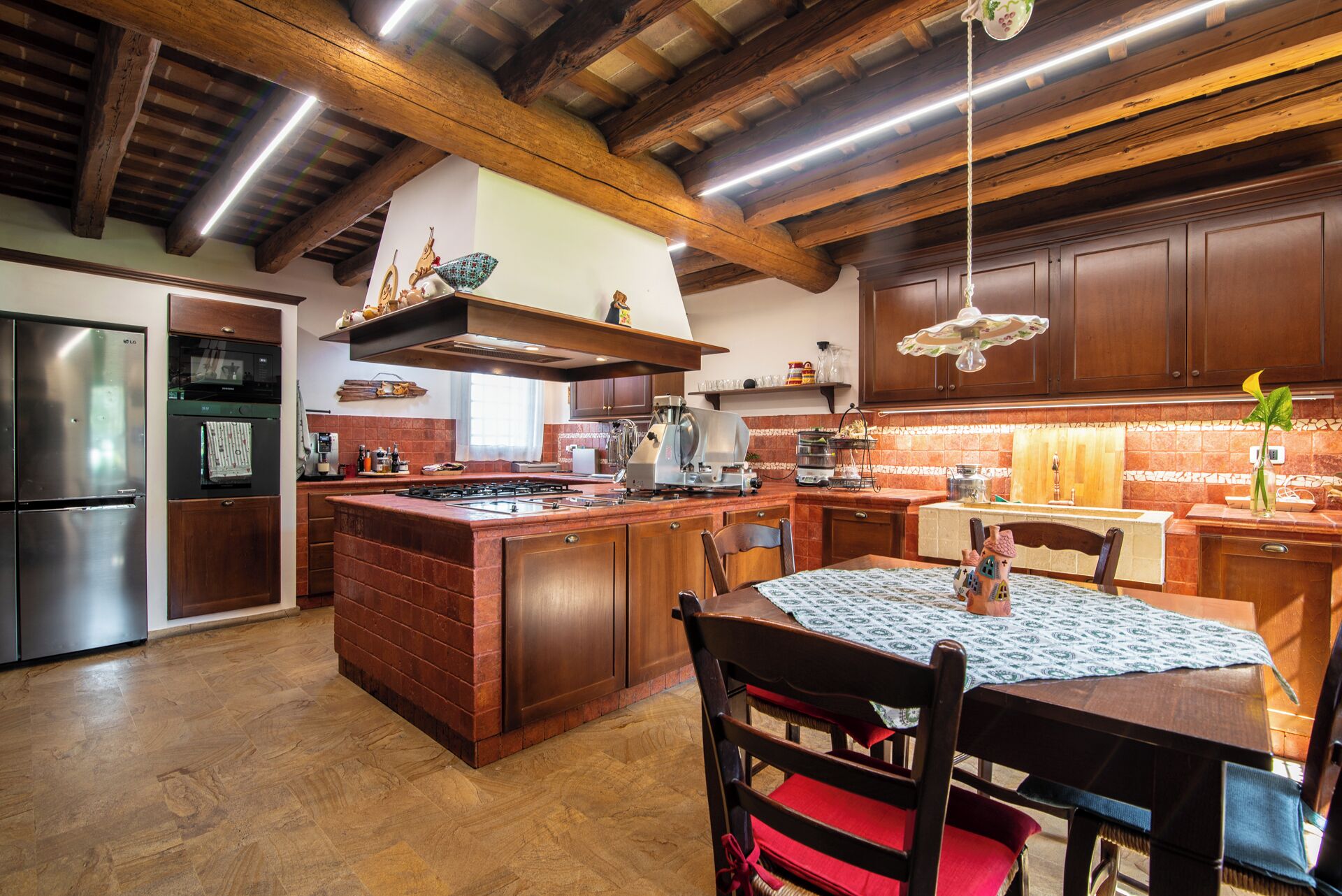 A spacious kitchen with a central island, wooden cabinets, and modern appliances.