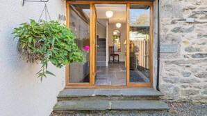 A stone building entrance with a wooden door and steps leading up to a staircase. - The Royal Oak Barn Cartmel - Sleeps 4 (Cartmel)