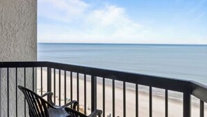 Ein Balkon mit Blick auf den Strand und das Meer.