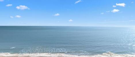 A beach with a clear sky and calm sea.