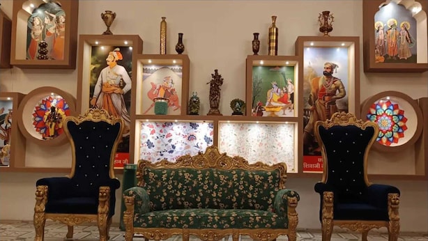 A room with a green sofa and two ornate chairs, framed artwork on the walls, and decorative vases. - Palette Hotel and Resort LBS INT (Pindra)