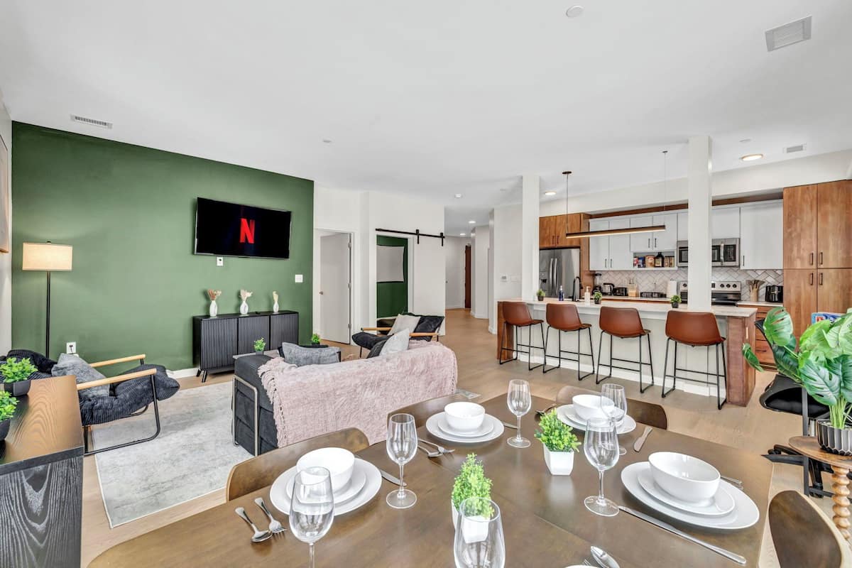 A modern apartment with a dining area, kitchen, and living room.