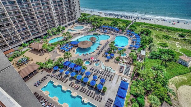 Un hôtel doté de plusieurs piscines, d’une plage et offrant une vue sur l’océan.