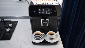 Une machine à café avec deux tasses de café posées sur un comptoir de cuisine.