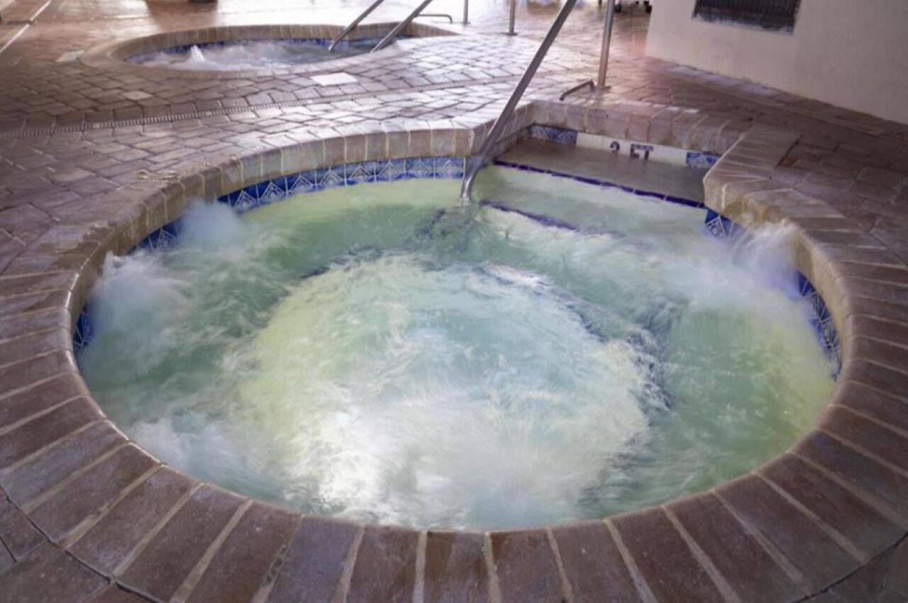 Un jacuzzi de diseño circular y suelo de baldosas.
