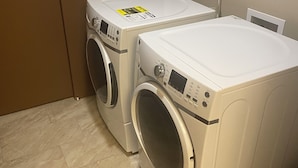 Une buanderie équipée de deux machines à laver à chargement frontal et d’un sèche-linge.