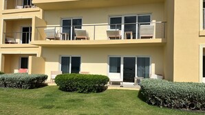 Un immeuble à plusieurs étages doté de balcons, de grandes fenêtres et d’une pelouse bien entretenue.