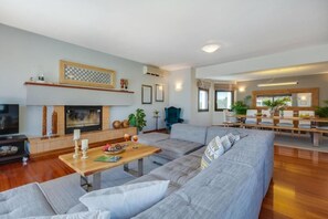 Una sala de estar moderna con chimenea, un comedor y un espacio de estar.