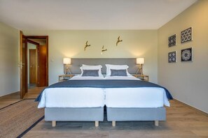A double bed with two bedside tables, a wall-mounted light fixture, and three wall-mounted bird decorations. - Villa Ampelaki (Chania)