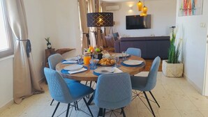 A dining area with a round table, blue chairs, and a variety of breakfast items. - Apartments Mia with new whirlpool from 2026 and 7 minutes walk from the beach (Okrug Gornji)