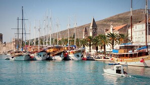 A marina with several sailboats docked, a small motorboat, and a building with a bell tower. - Apartments Mia with new whirlpool from 2026 and 7 minutes walk from the beach (Okrug Gornji)