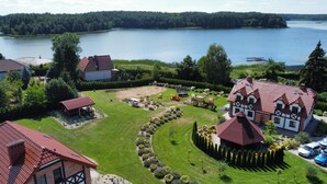 Une propriété située au bord d’un lac, comprenant une grande maison, une plus petite et un terrain de jeux.