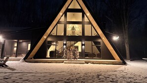 Un edificio moderno de forma triangular, con amplios ventanales y una escalera que sube al piso superior.
