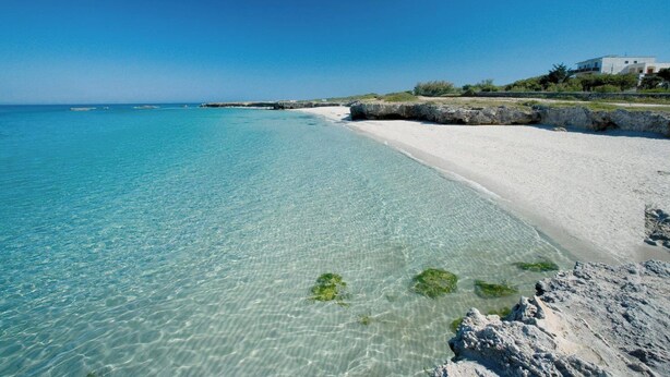 A beach with clear turquoise water, white sand, and rocky outcrops. - Poésia – Portuligno Apartment 50 mt from the most beautiful beaches in Salento! (melendugno)