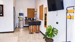 A modern kitchen with a microwave, refrigerator, and wooden bar stools.