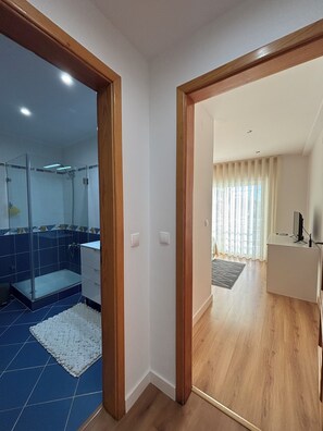 Un baño moderno con cabina de ducha de vidrio y un área de aseo separada.