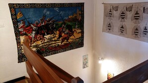 En trappe med et trægelænder og et billede på væggen, der viser en historisk krigsscene.