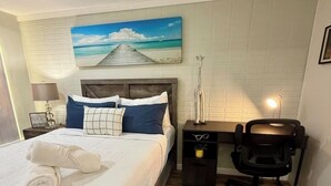 Une chambre bien rangée, avec un lit, un bureau et une chaise.