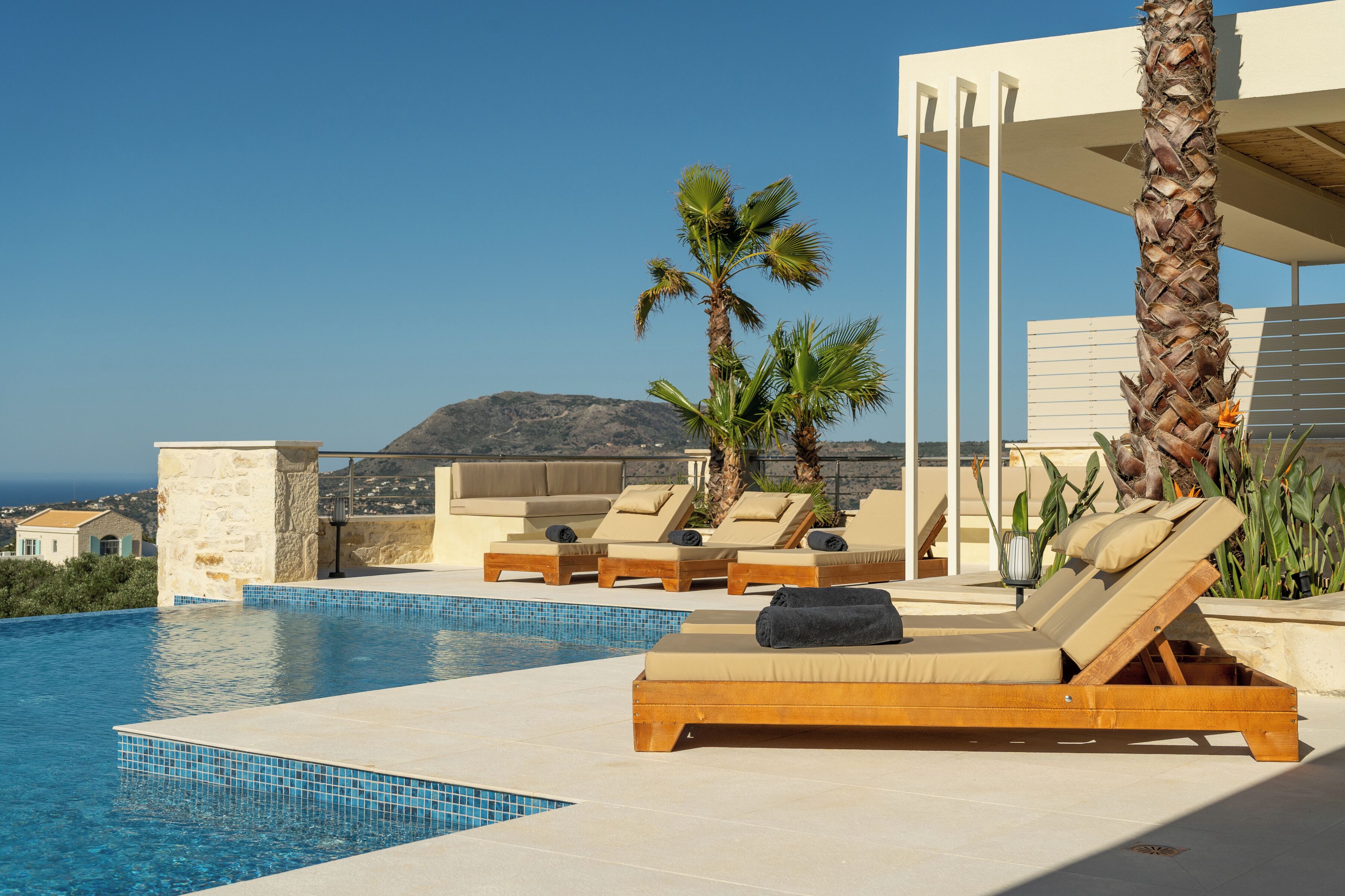 Una piscina al aire libre, sombrillas, tumbonas