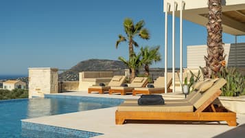 Una piscina al aire libre, sombrillas, tumbonas