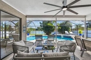 An indoor pool area with glass walls, a ceiling fan, and lounge chairs. - Private Sarasota Oasis with heated pool & 10 minutes to Siesta Key (Sarasota)