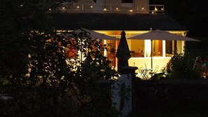 Een twee verdiepingen tellend huis met een balkon en een terras.