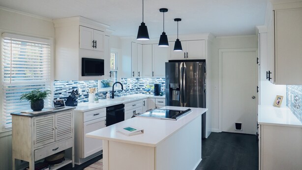 A modern kitchen with white cabinetry, a central island, a stainless steel refrigerator, and pendant lighting. - Masters Week Home Away from Home - 3BR Retreat Minutes from Augusta National (Augusta)