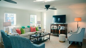 A living room with a sofa, two armchairs, a coffee table, a TV, and a ceiling fan. - Masters Week Home Away from Home - 3BR Retreat Minutes from Augusta National (Augusta)