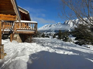 A wooden cabin with a balcony overlooking a snowy landscape and mountains. - Large family chalet Heritage Chalet (la joue du loup)