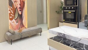 A modern kitchen with built-in appliances, a marble countertop, and a large decorative wall. - Adna Hotel (Lagos)
