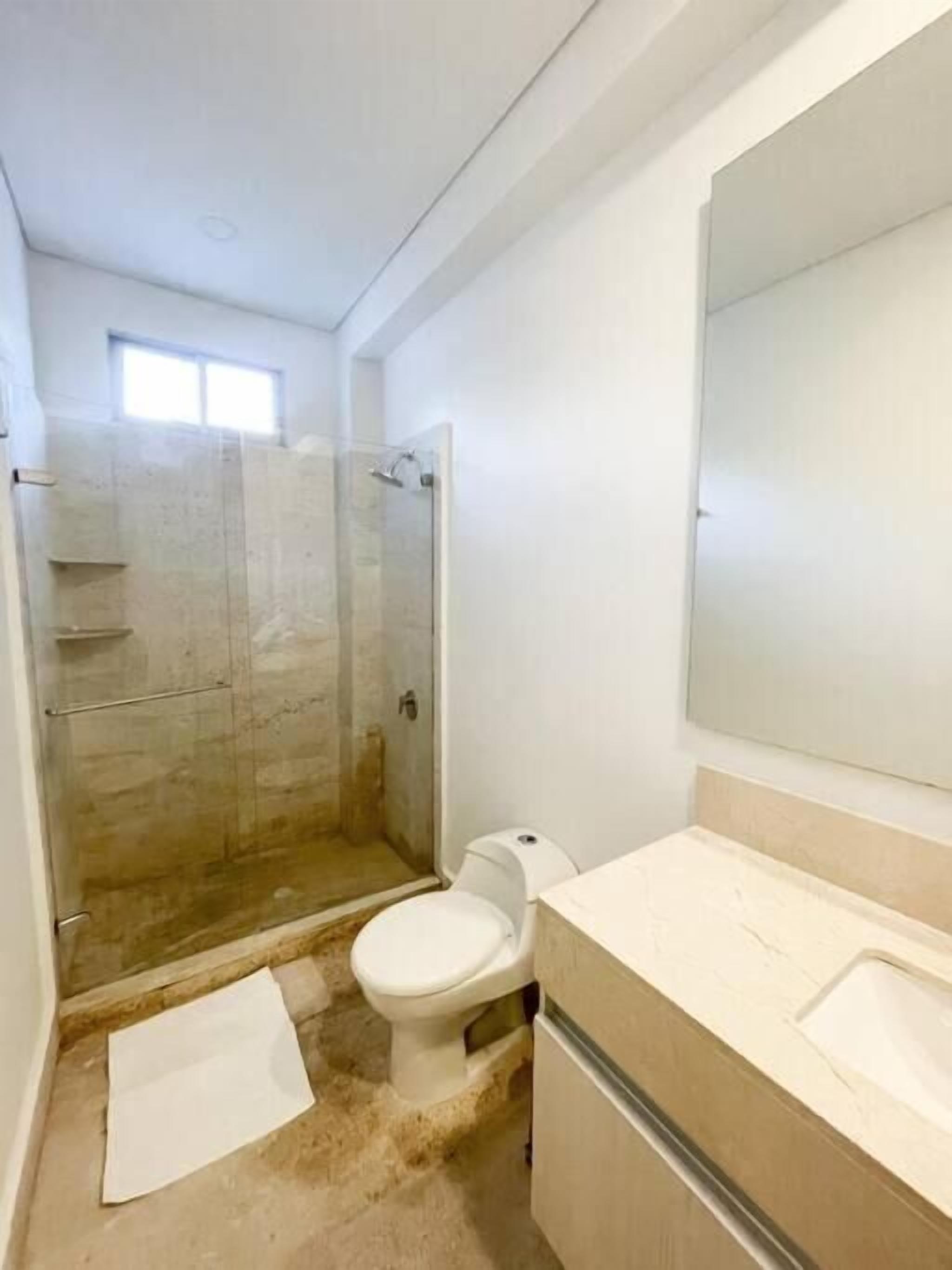 Une salle de bain avec douche, toilettes et lavabo.