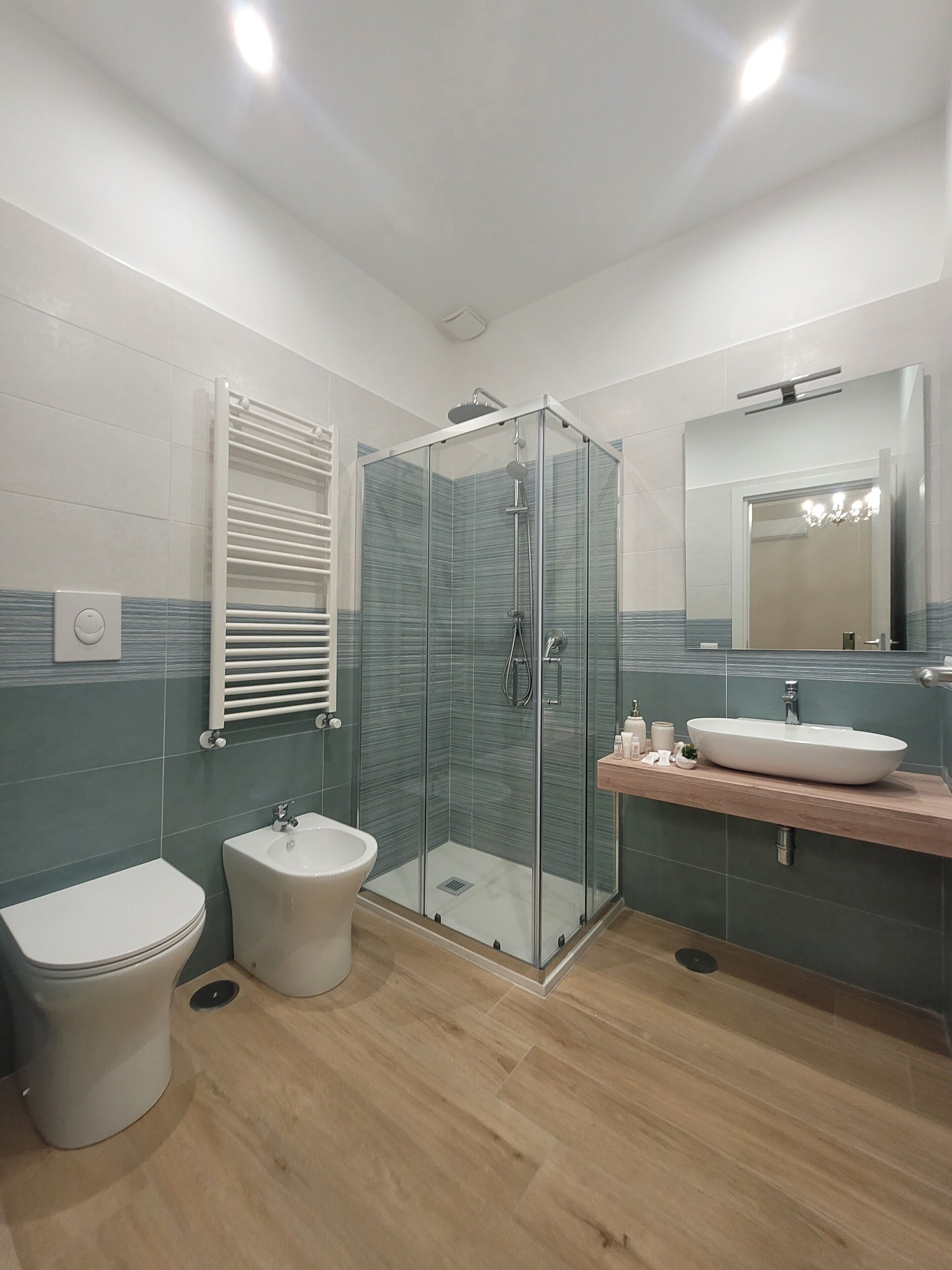 Une salle de bain moderne avec une douche à parois de verre, un lavabo sur colonne et des toilettes.