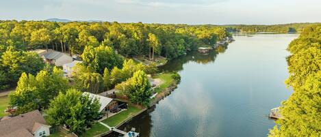 Propiedad frente al río con muelle, casas y abundante vegetación.