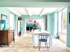 A spacious room with a dining table, chairs, a wooden cabinet, and a kitchen area in the background. - New Spacious Provençal Villa | Private Pool | Sleeps 10 | Peaceful Countryside (Verquières)