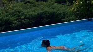 Una piscina con agua cristalina azul y una cubierta de madera.