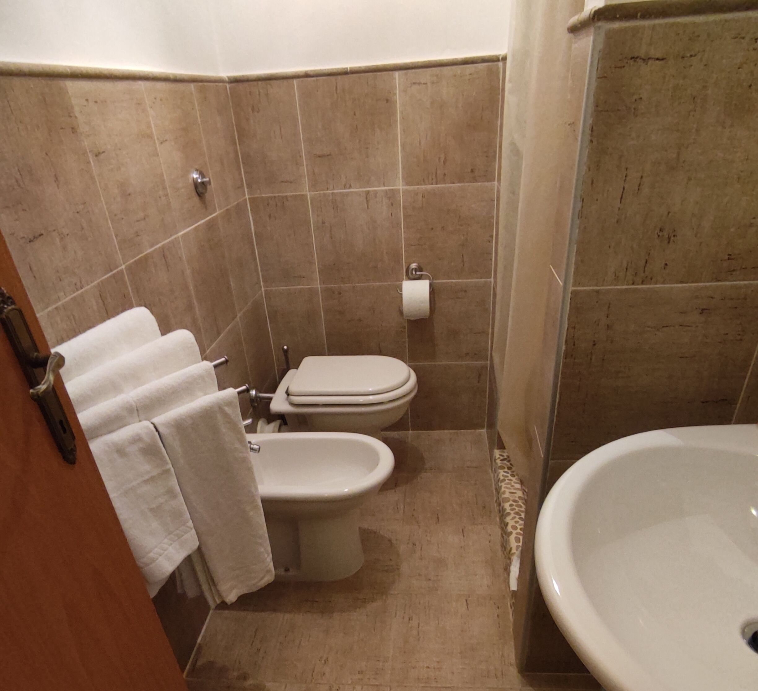 Une petite salle de bain avec des toilettes, un bidet et un lavabo.