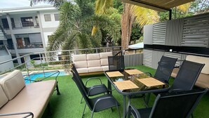 An outdoor patio with a pool, a sofa, and a table with chairs. - 1 Bedroom condo in Coco with pool, close to beach (Playas del Coco)