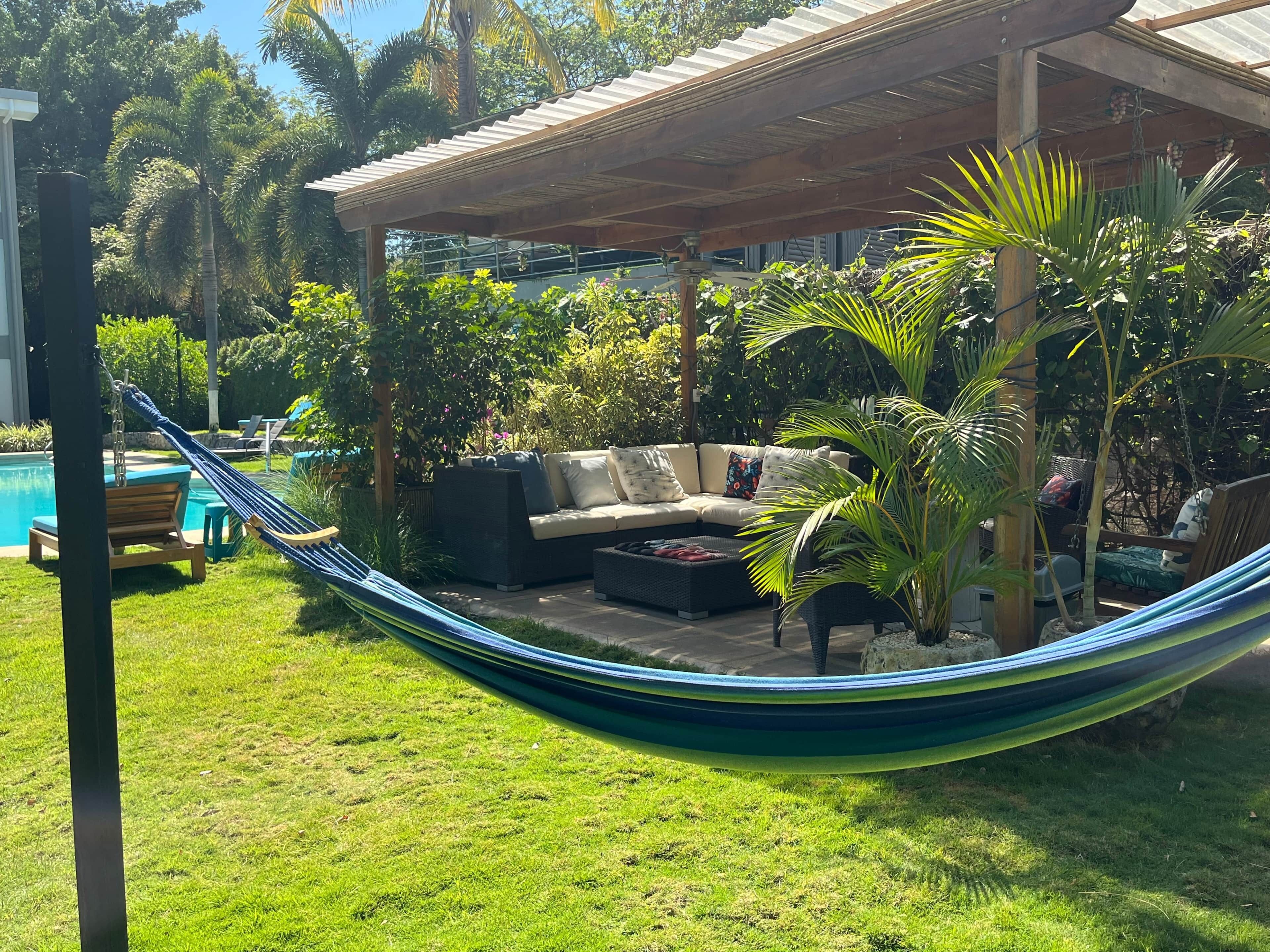 Un hamac, un espace de détente abrité et une piscine.