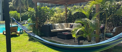 A hammock, a covered seating area, and a pool.