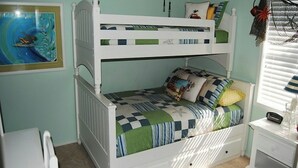 A bunk bed with a checkered bedspread and pillows, a white dresser, and a framed picture on the wall. - Guest Cottage 20- 2BR House- Community Pool (Myrtle Beach)