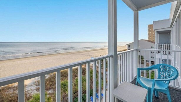 Ein Balkon mit Blick auf Strand und Meer.