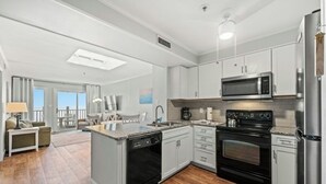 Eine moderne Küche mit Edelstahlgeräten, einer Kochinsel und Blick auf einen Balkon.
