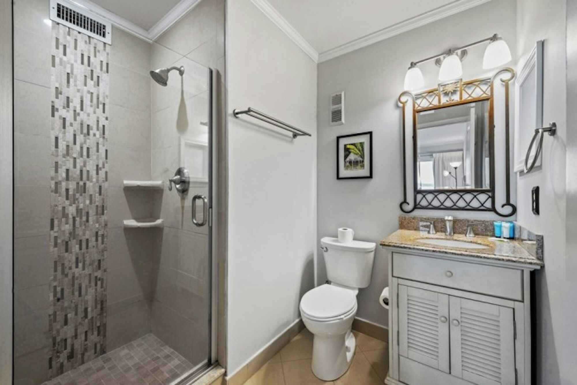 A bathroom with a shower, toilet, sink, and vanity.
