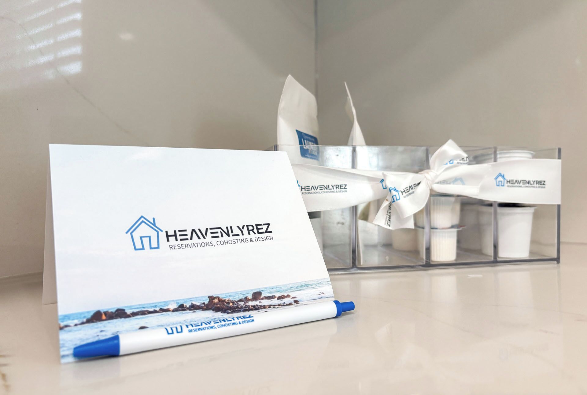 A brochure for Heavenlyrez with a coastal image, a pen, and a candle holder with candles.