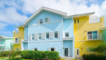 Un edificio residenziale a più piani con facciata azzurra, persiane bianche e balconi.