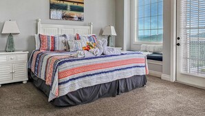 A bedroom with a bed, two bedside tables, a window with blinds, and a painting on the wall. - L-6 Gorgeous views, clean cozy near SDC (Branson)