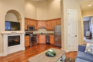 A modern kitchen with wooden cabinets, stainless steel appliances, and a built-in TV. - L-9 Cozy, clean close to SDC stunning views (Branson)
