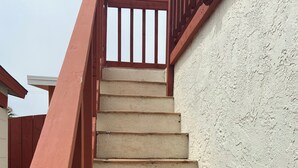 Unes escales de fusta amb barana que condueixen a un balcó.